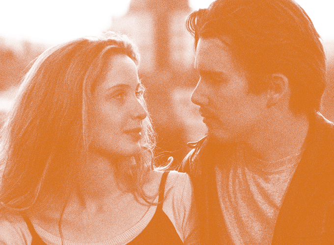 Couple facing each other and talking outdoors, with an orange-tinted photo filter.